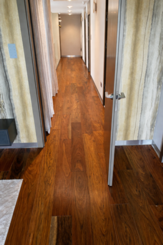 Drewniana podłoga amazouke w korytarzu z widokiem na drzwi i detale wykończenia